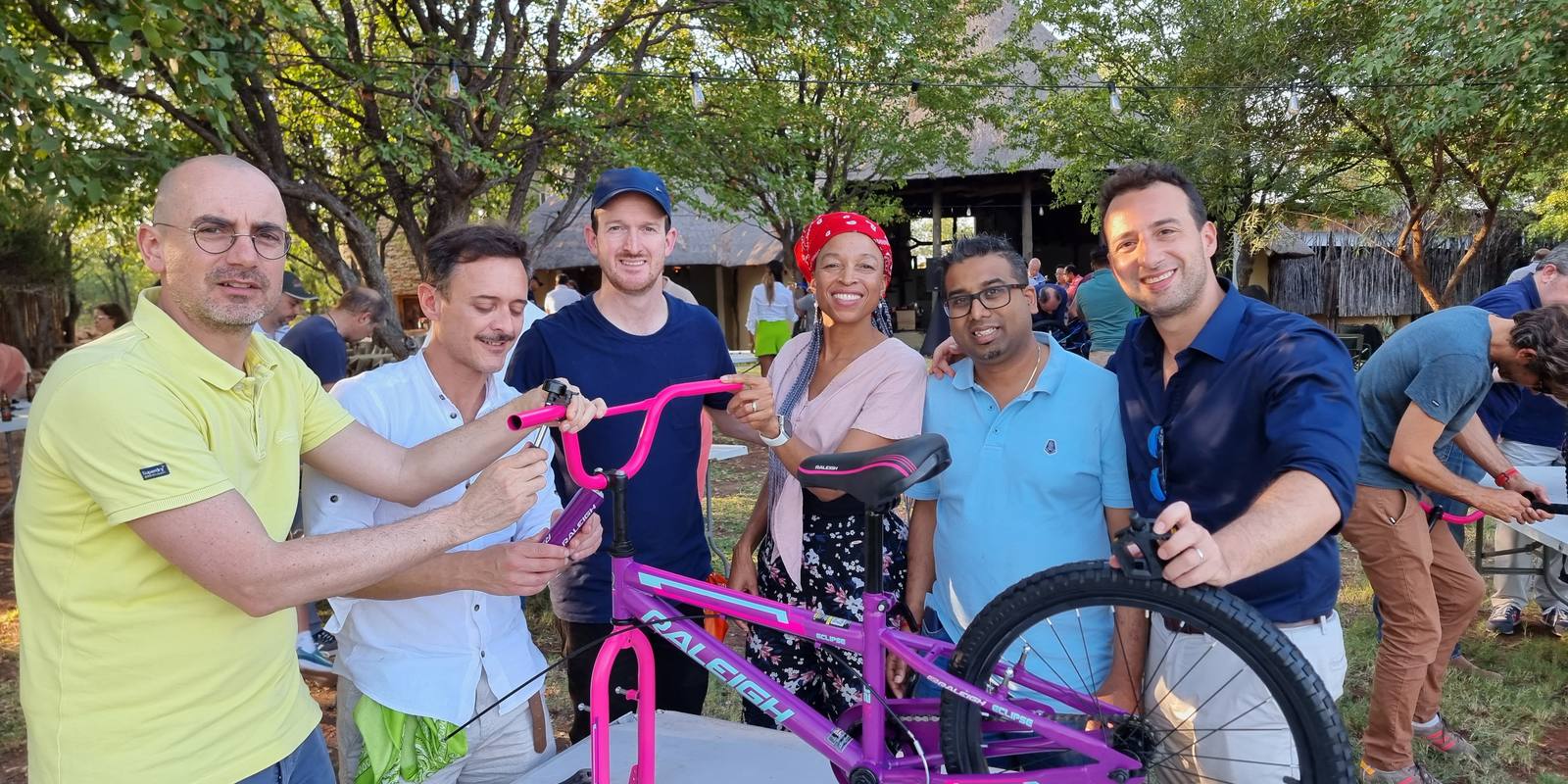 A team with a bicycle they built for a children's charity