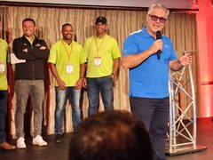 Mark Maguire speaking on stage at a company conference