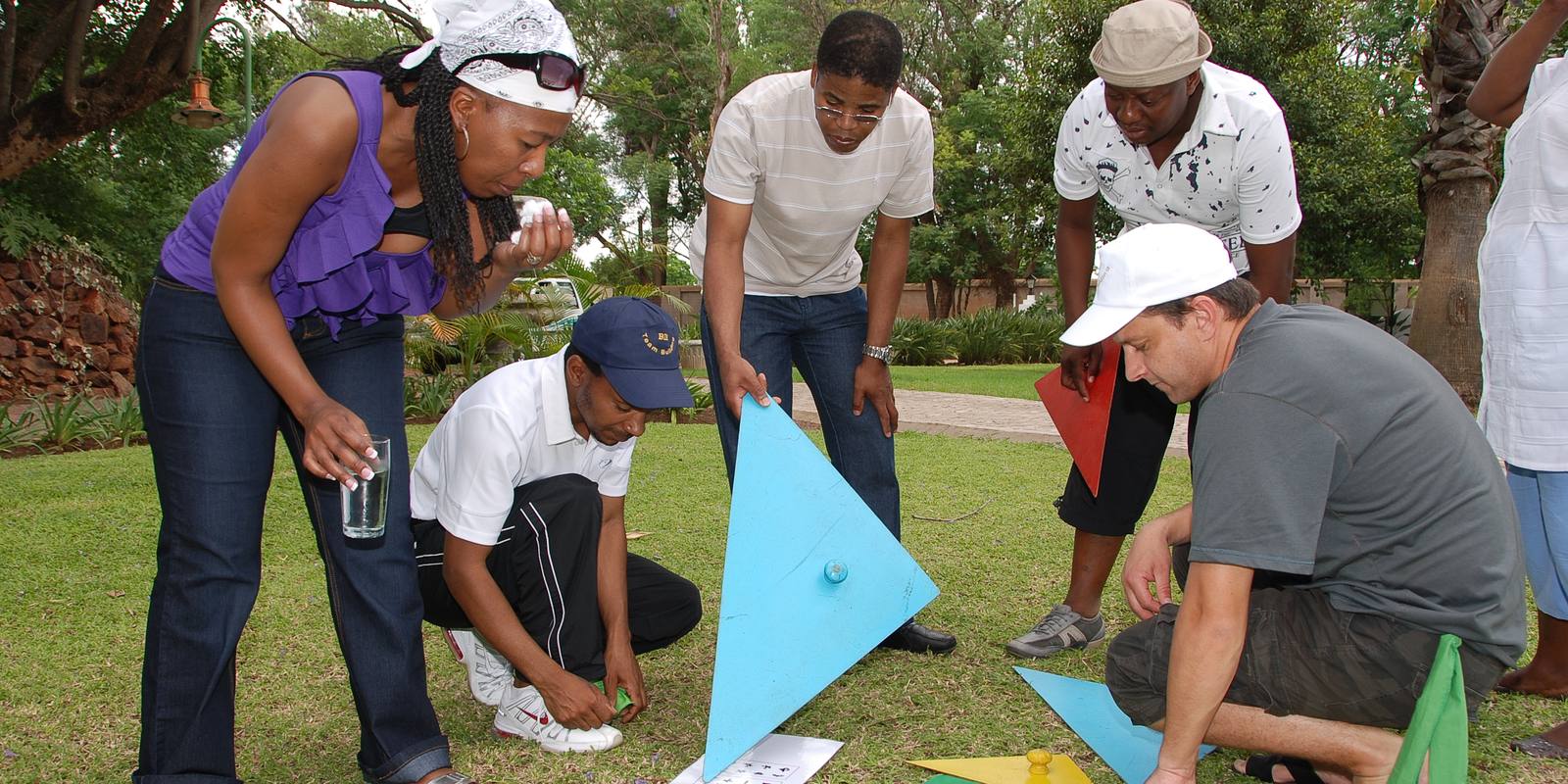 A team working out a puzzle together on the lawn